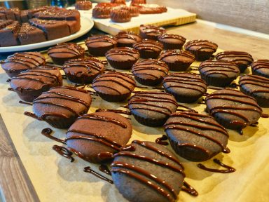 Schokoladenkekse mit Schokoladenglasur auf einem Holzbrett.