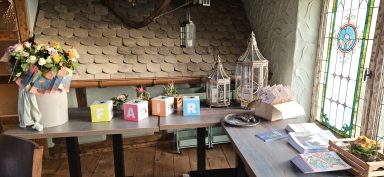 Ein gemütlicher Raum mit einer Blumenarrangement, Laternen und bunten Boxen auf einem Tisch.