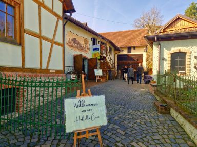 Eingang zu einem historischen Gebäude mit Steinfussboden und Besuchergruppen.