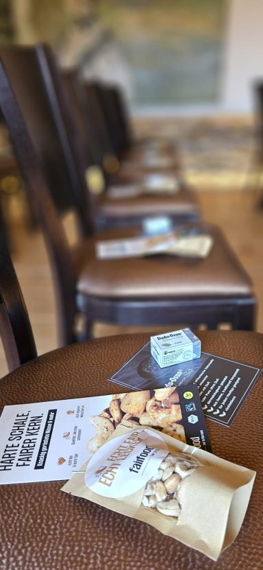 Reihe von Stühlen mit Prospekten und einer Tüte auf den Sitzflächen.